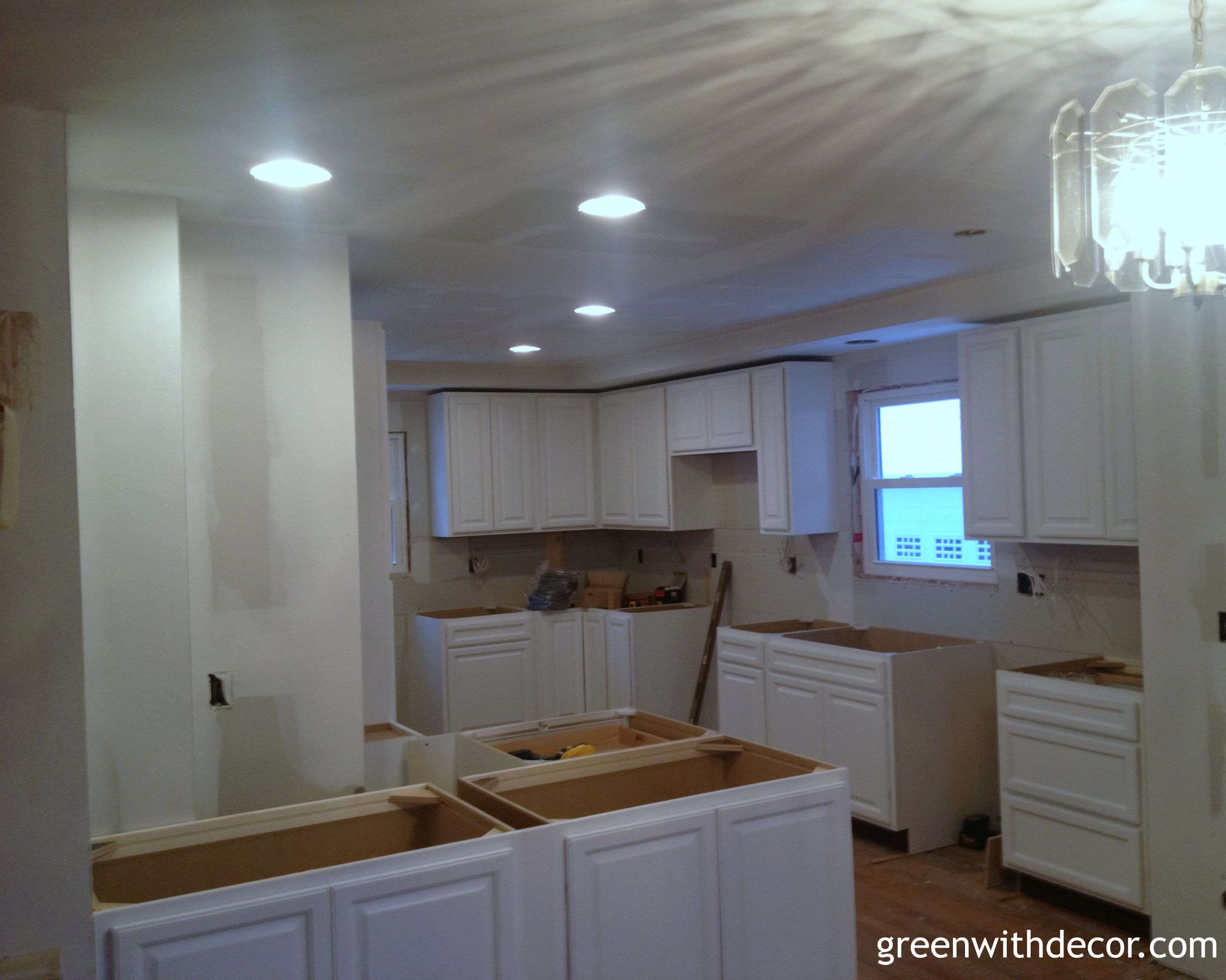 White cabinets installed in the kitchen! If you need a lower cabinet for a tight spot, think about using an upper cabinet. | Green With Decor 