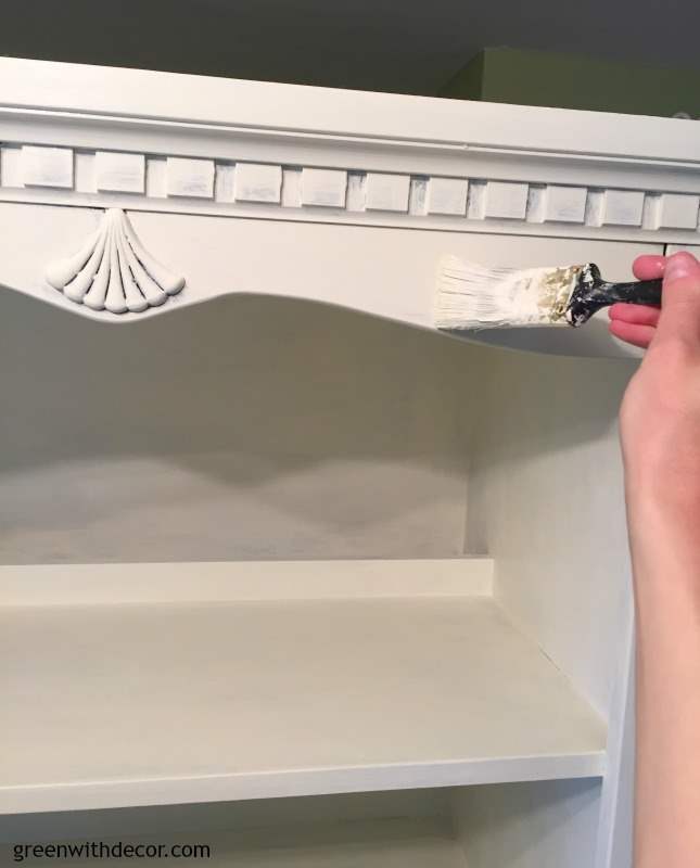 White bookshelf with trim and seashell being painted white. 