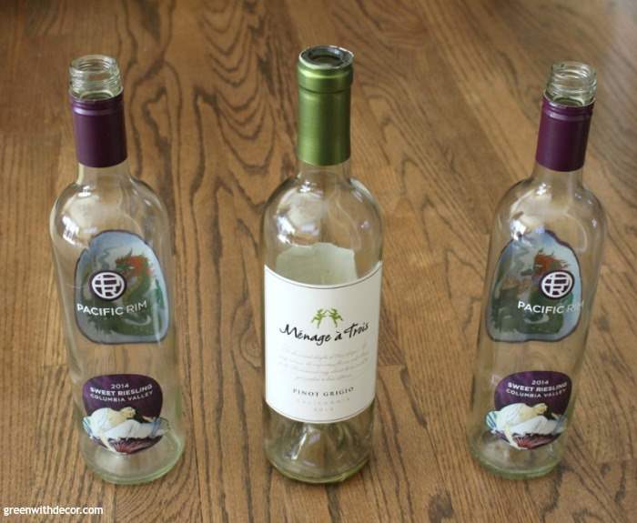 Three wine bottles on a table for a craft project