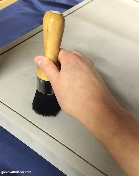 Applying wax to a gray painted table