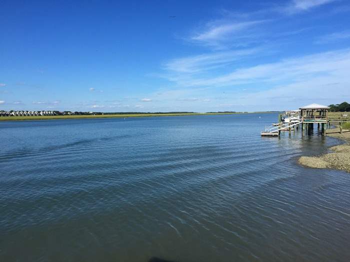 A serene view of the water with blue skies in Folly Beach.
