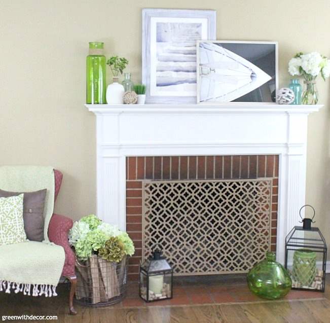 What to use for a summer mantel | Love the beachy picture frames with the colored glass vases and rope sphere | summer decorating ideas for the mantel | summer decor | mantel decorating ideas 