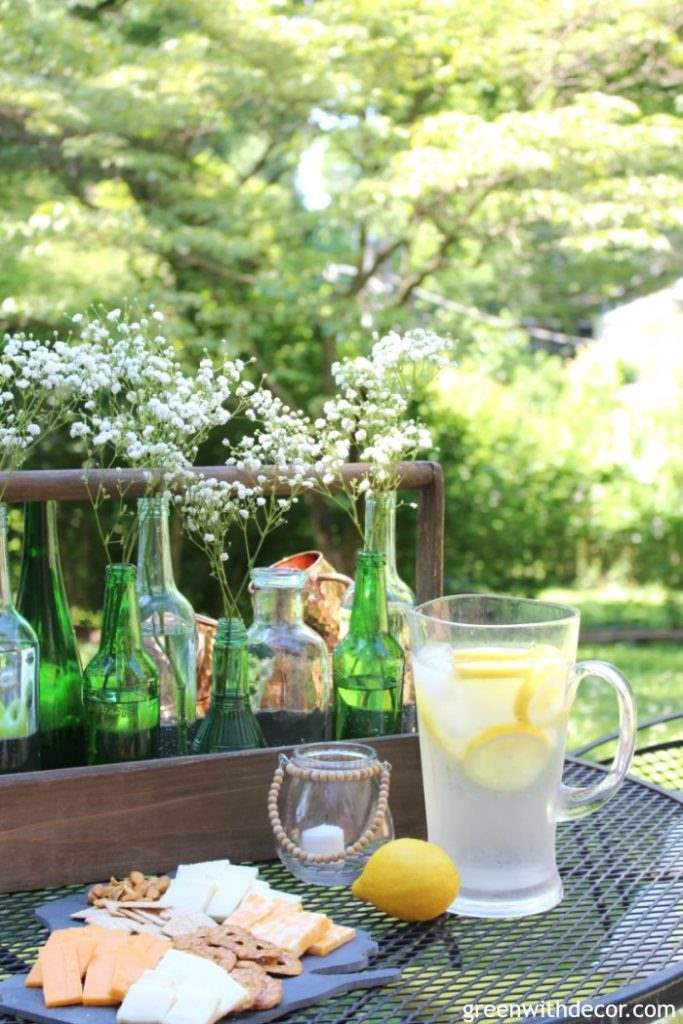 How to easily decorate a rental patio plus a great idea for a summer centerpiece using an old wood toolbox and glass bottles. Love how she updated this old patio for summer!