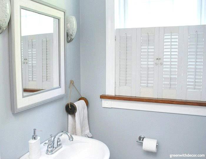 Small bathroom makeover for just $100. Perfect for renters! Love the coastal and farmhouse design - the towel rack is an old wooden spool. Great storage for a small bathroom!