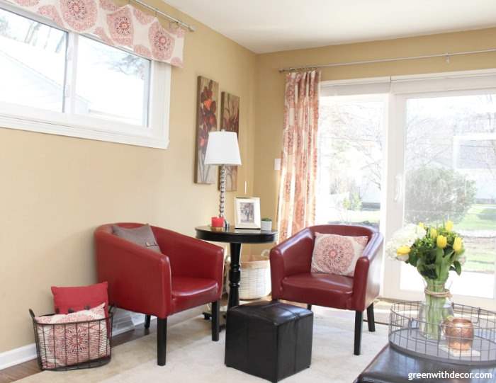 How to find your decorating style – a tan family room with red chairs and curtains
