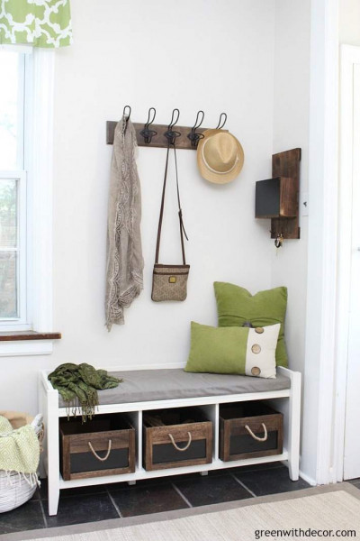 Mudroom with Aesthetic White walls, a white bench, green pillows and wood hooks
