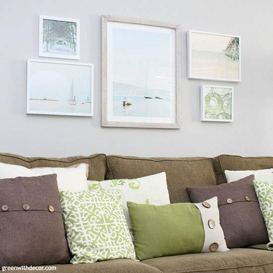 Artwork displayed on a light grey wall over a brown couch