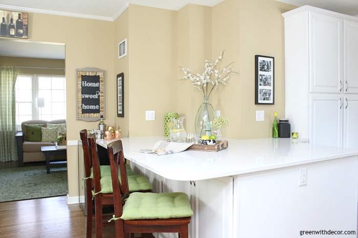 Such a pretty tan paint color! It's Sherwin Williams' Camelback, such a nice warm neutral! Looks great in this white kitchen with green and aqua accents!