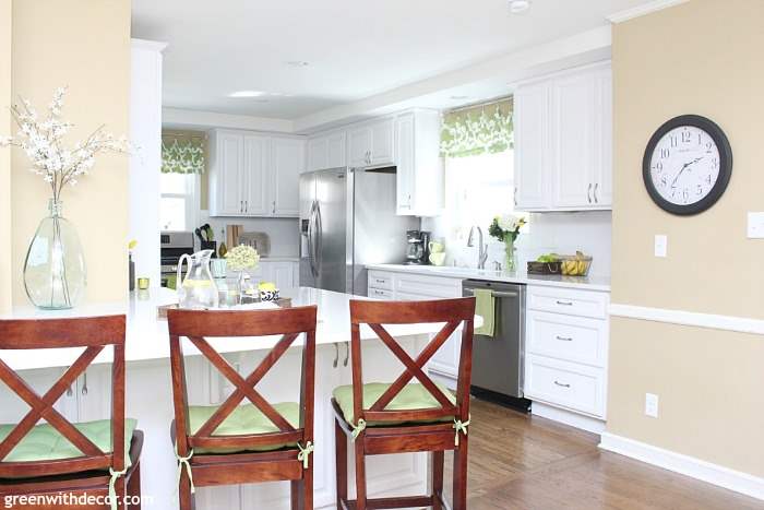 A gorgeous white kitchen renovation reveal with quartz counters, white cabinets, Camelback walls, stainless steal appliances and fun rustic coastal touches