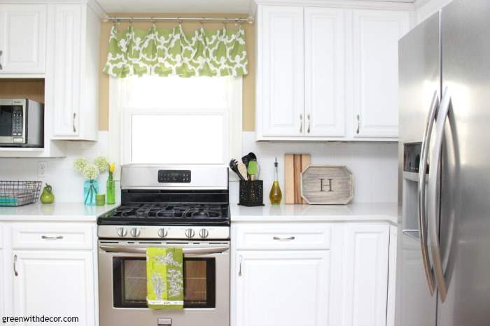 A gorgeous white kitchen renovation reveal with quartz counters, white cabinets, Camelback walls, stainless steal appliances and fun rustic coastal touches. Love the wood cutting board.