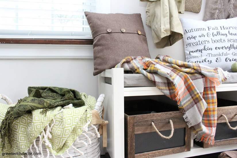 A small mudroom with Aesthetic White walls, wood and rope crates and a white bench