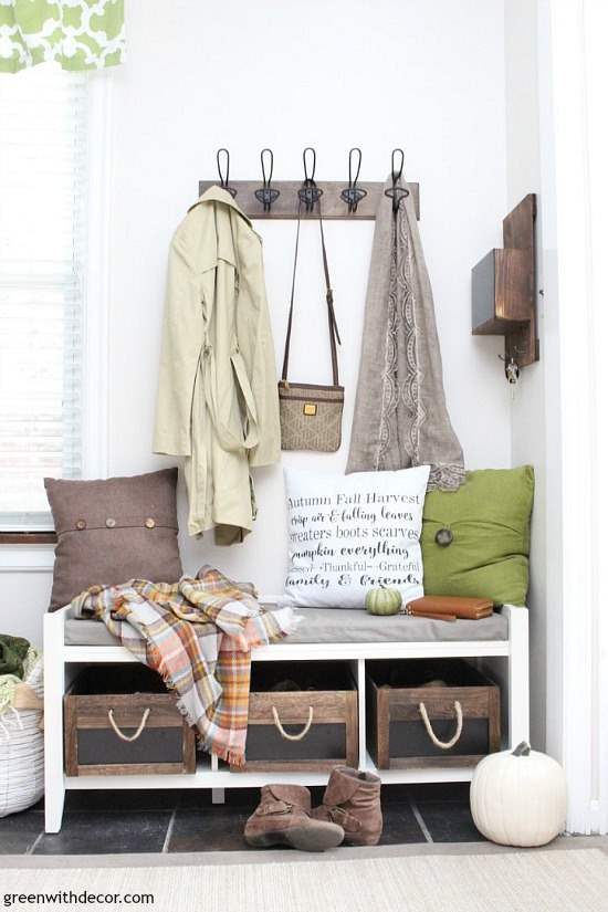 A small mudroom with white walls, decorated for fall