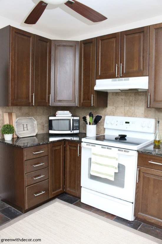 Kitchen with dark brown cabinets, Aesthetic White paint on the walls and a white stove.