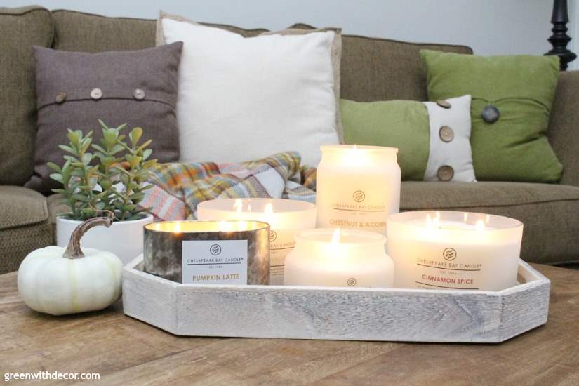 Delicious smelling fall candles in neutral colors. This coastal farmhouse living room looks so cozy! Love that faux plant.