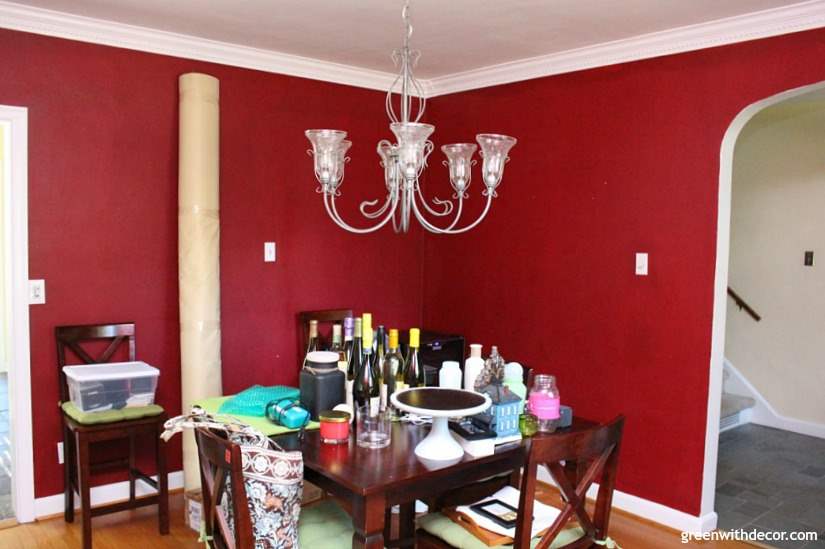 A dining room painted red with a silver light fixture