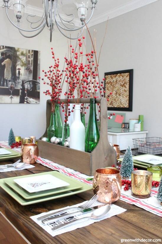 A wooden toolbox centerpiece with wine bottles and red berries