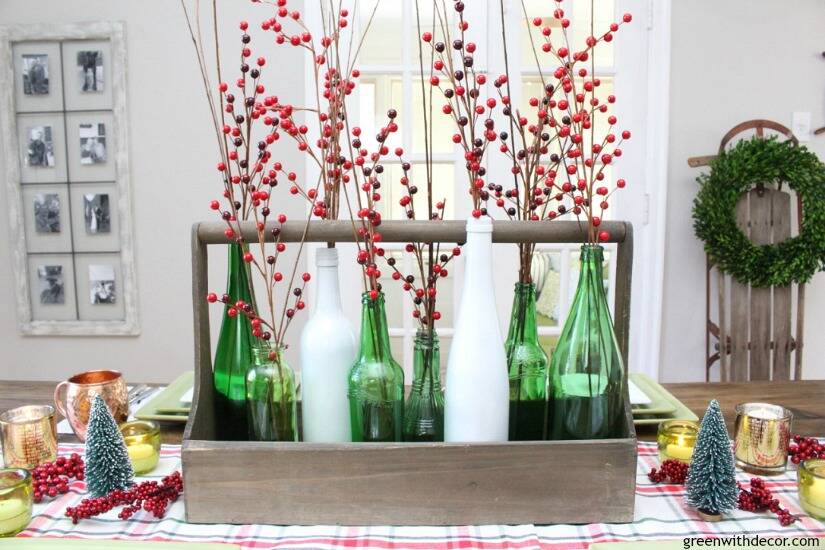 A plaid Christmas centerpiece and tablescape. Love the pretty old bottles with the red Christmas berries and ornaments.