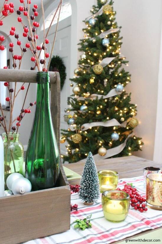 A plaid Christmas centerpiece and tablescape. Love the pretty old bottles with the Christmas berries and ornaments.