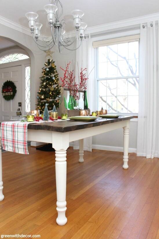 A plaid Christmas centerpiece and tablescape. Love those pretty bottles with the Christmas berries and ornaments. And that gorgeous farmhouse dining table - they built it!