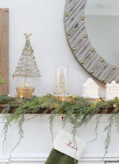 A simple Christmas mantel with village pieces and pretty faux garland