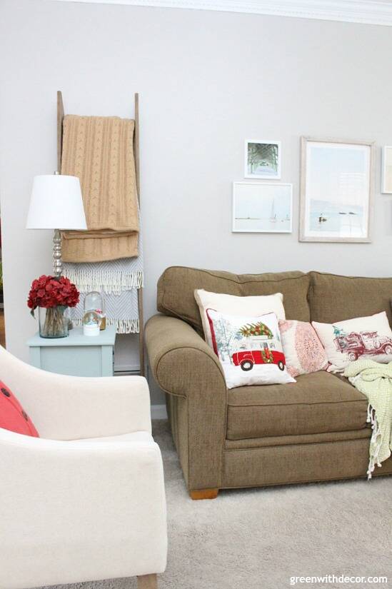 A traditional Christmas living room filled with red, green and metallic decor. Love that ladder blanket behind the table, such a good use of space!