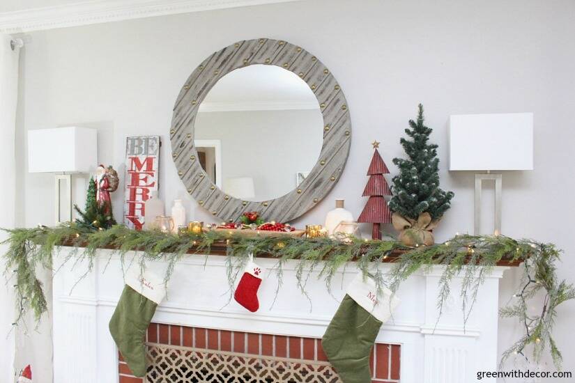 A traditional Christmas mantel - full of red, green, metallic and neutral pieces. Love the faux garland with that gray wood mirror!