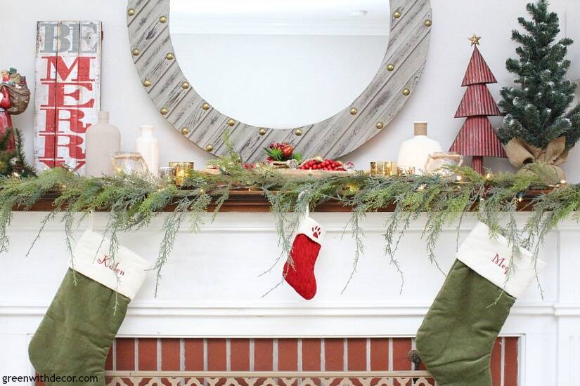 A traditional Christmas mantel - full of red, green, metallic and neutral pieces. Love the faux garland and gorgeous gray wood mirror!
