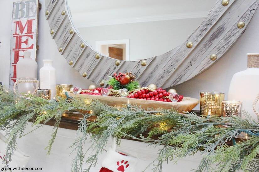 A traditional Christmas mantel - full of red, green, metallic and neutral pieces. Love that faux garland and gorgeous wood mirror!