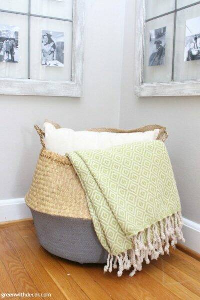 Such a pretty coastal seagrass and gray basket, the green blanket and white pillow look great inside - such easy decorating for a corner!