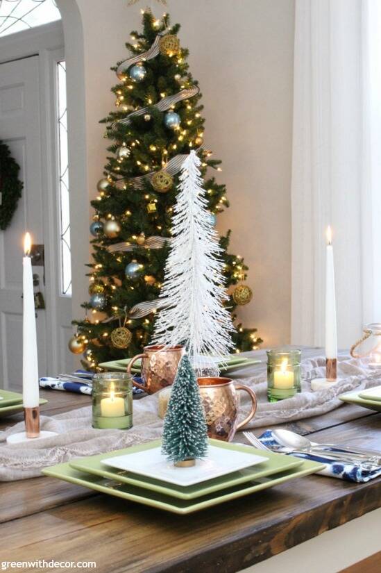 A blue and copper Christmas centerpiece + tablescape - perfect for a costal tablescape! Love the tree in the corner of the dining room and all of those pretty mini Christmas trees for the centerpiece on the table!