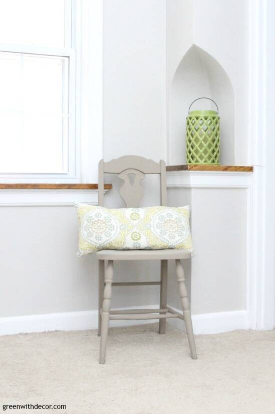 Gray hallway with farmhouse chair, patterned pillow and green lantern in an old phone nook