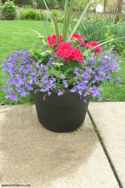 A painted plastic outdoor planter with colorful flowers