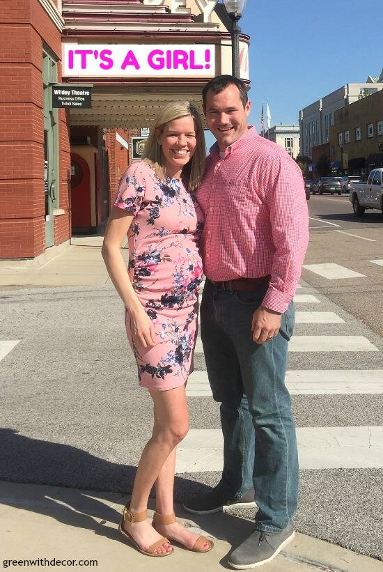 A gender reveal announcement in front of a movie theater, with a sign that says "It's a girl!"