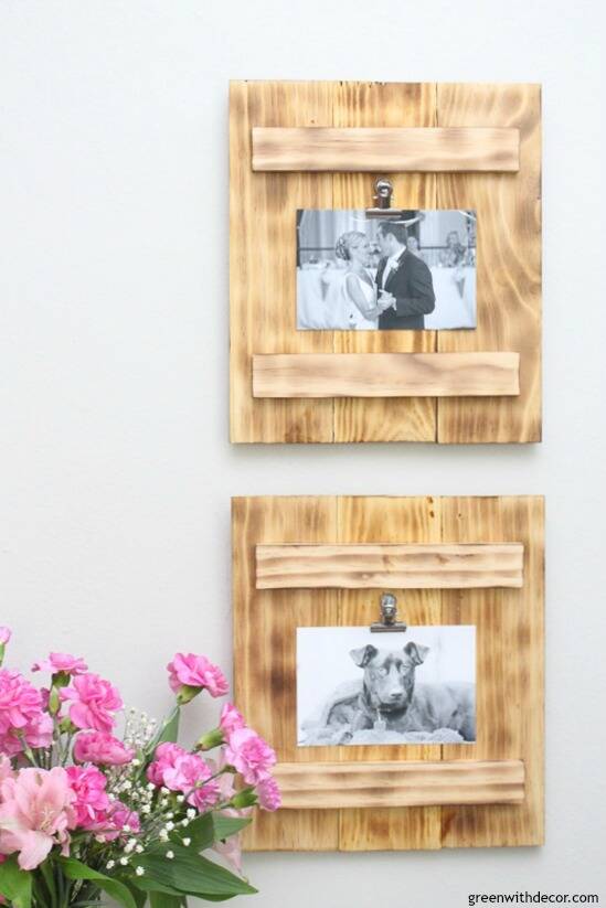 DIY picture frames with a burned wood finish hanging on a gray wall near pink flowers