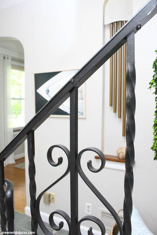 Gray coastal foyer with a black metal railing and old charming gold doorbell chimes