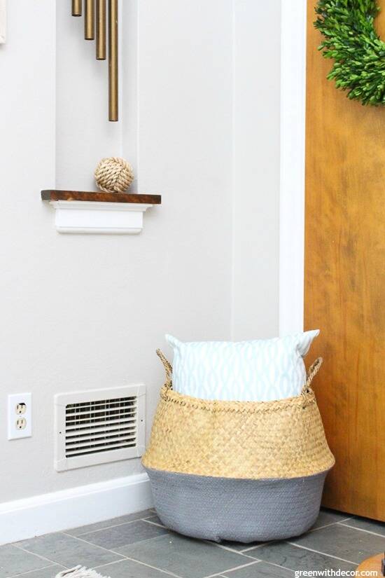 Gray coastal foyer with a seagrass basket and aqua and white pillow