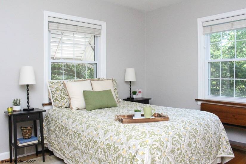 A neutral, blue and green bedroom with gray walls, white trim and black nightstands