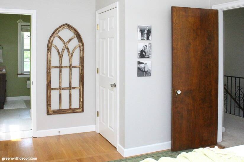 Gray walls with a rustic wood arched window and black and white photo canvases