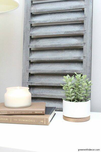 Faux plant with candle and brown books