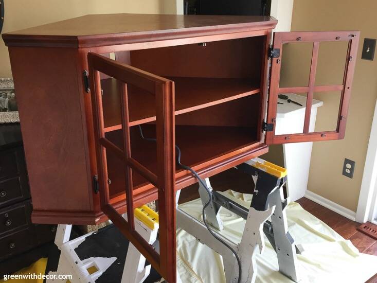 A brown wood TV stand before being painted