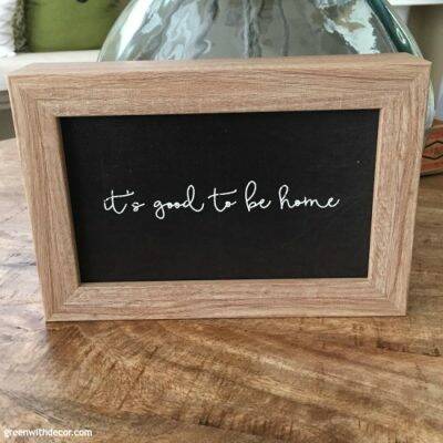 Black and wood sign, "It's good to be home"