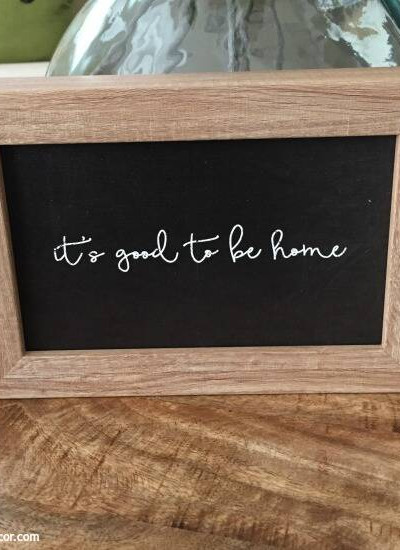 Black and wood sign, "It's good to be home"