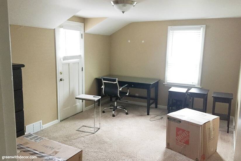Tan guest room with black desk and tables on moving day
