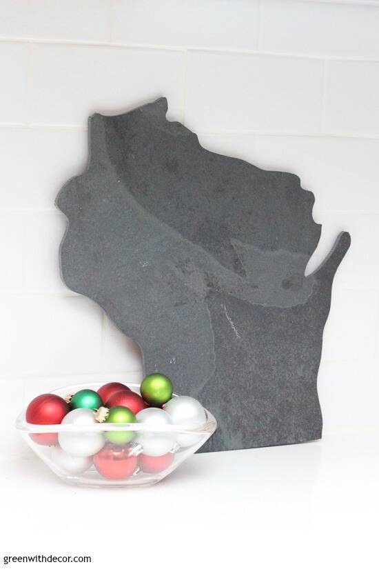 Wisconsin cutting board with clear glass bowl full of Christmas ornaments