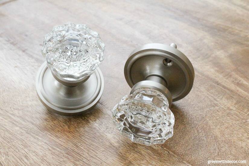 Crystal door knobs with silver plates sitting on wood surface