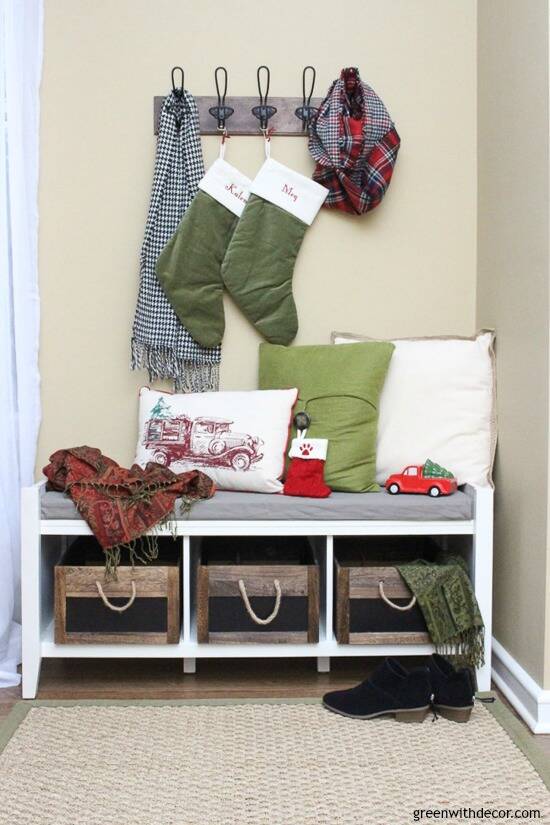 Christmas mudroom with green stockings, rustic crates and metal hooks