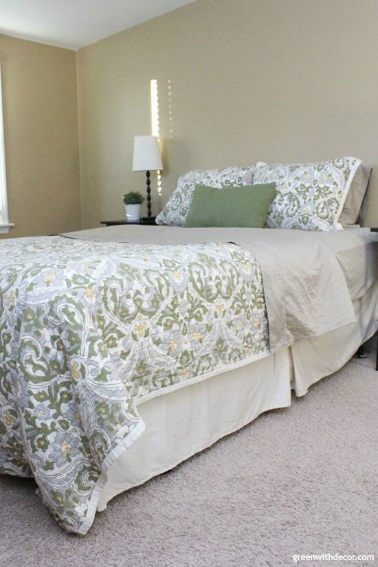 Bedroom with Camelback walls, a cream bedskirt and a blue/green comforter