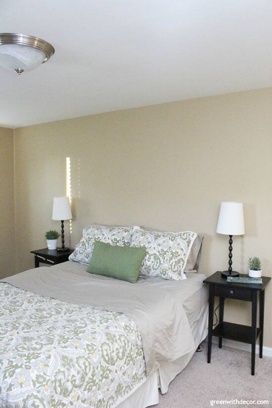 Bedroom with Camelback walls, black nightstands and blue/green comforter