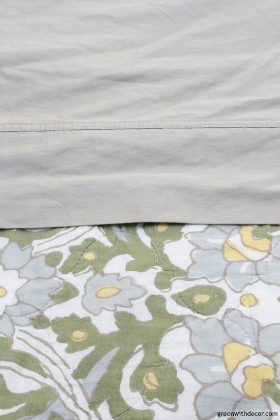 Tan sheets with tan, white, blue and green bedspread