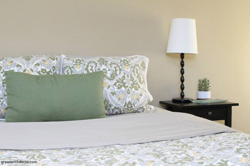 Bedroom with tan walls and green and blue comforter